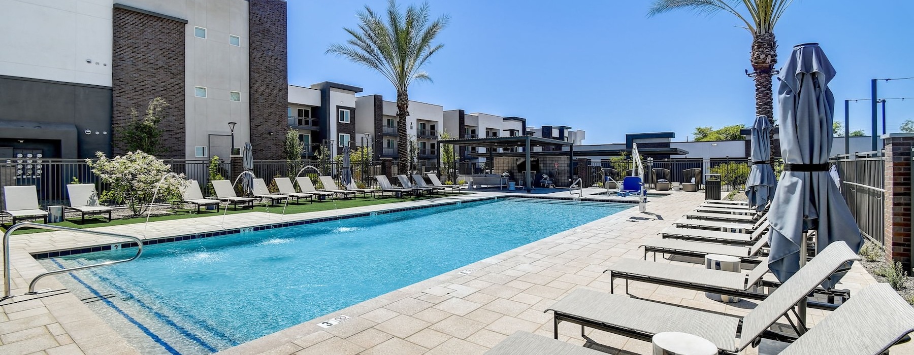 a swimming pool with lounge chairs and palm trees